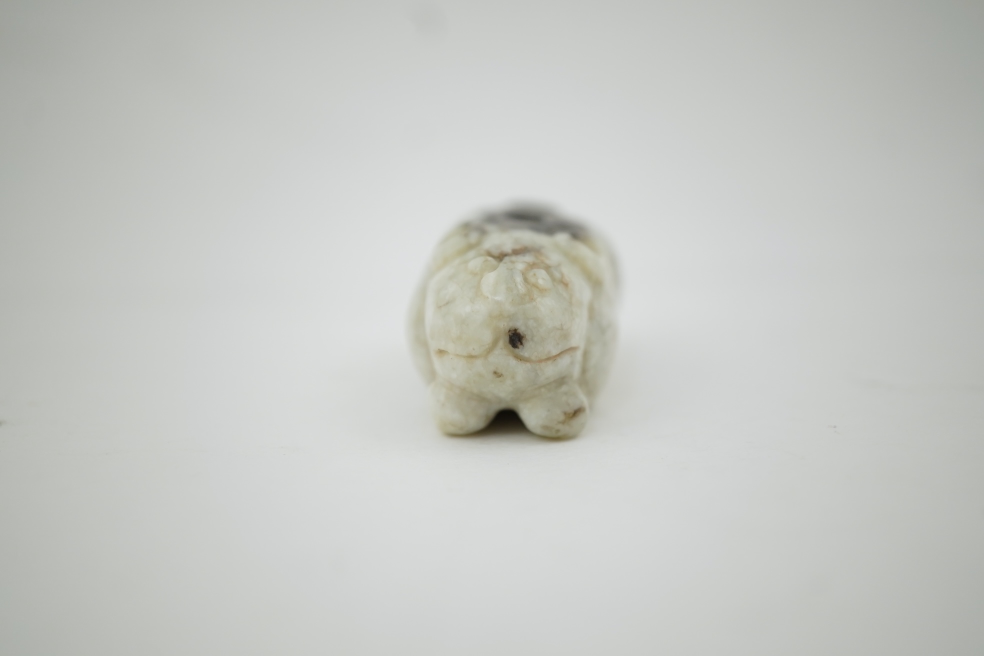 A Chinese white and black jade figure of a recumbent tiger, Song dynasty